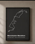 Personalised route trace print, in a black frame, portrait, with a white route line on a charcoal background above a title, date and finish time, hanging on a wall.